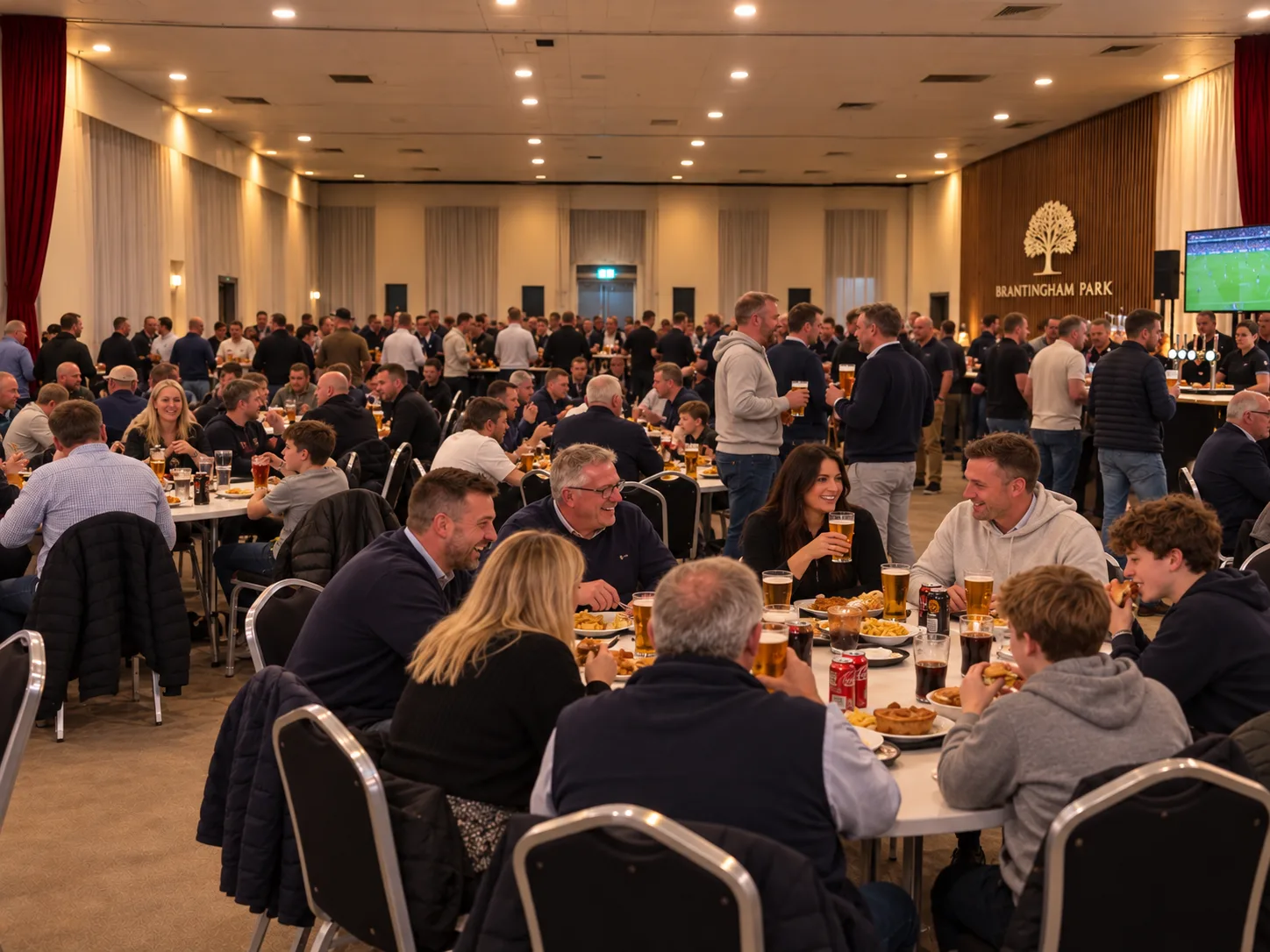 Football supporters eating and drinking inside Brantingham Park Fan Zone